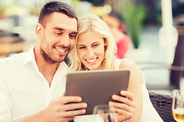 Image showing happy couple with tablet pc at restaurant lounge