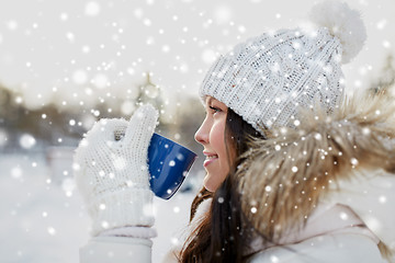 Image showing happy young woman with tea cup outdoors in winter