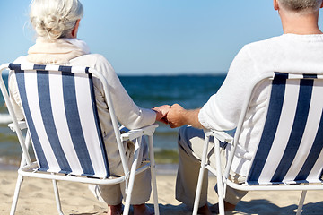 Image showing senior couple sitting on chairs at summer beach