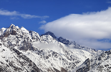 Image showing Snow winter mountains and blue sky with clouds at sun day