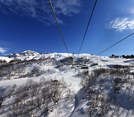 Image showing Chair-lift at ski resort in sun winter day