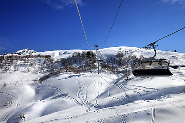 Image showing Chair-lift at ski resort in sun winter day