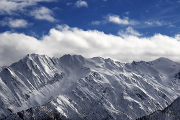Image showing Snow winter mountains and cloud sky in sun evening