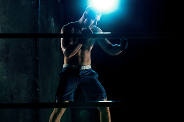 Image showing Male boxer boxing in a dark studio