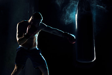 Image showing Male boxer boxing in punching bag