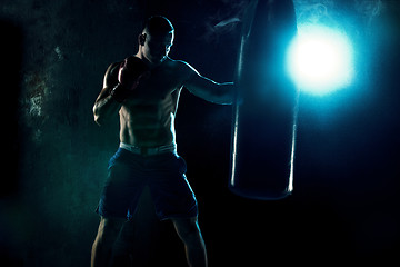 Image showing Male boxer boxing in punching bag