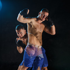 Image showing Male boxer boxing in a dark studio