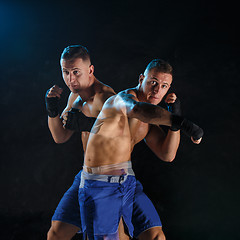 Image showing Male boxer boxing in a dark studio