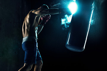 Image showing Male boxer boxing in punching bag