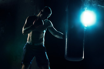 Image showing Male boxer boxing in punching bag