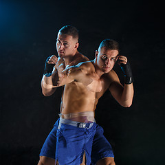 Image showing Male boxer boxing in a dark studio