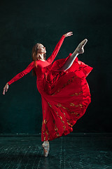 Image showing Ballerina posing in pointe shoes at black wooden pavilion