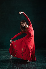 Image showing Ballerina posing in pointe shoes at black wooden pavilion