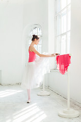 Image showing Ballerina posing in pointe shoes at white wooden pavilion