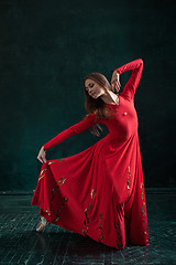 Image showing Ballerina posing in pointe shoes at black wooden pavilion