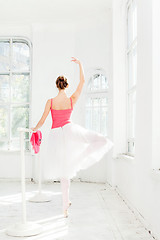 Image showing Ballerina posing in pointe shoes at white wooden pavilion