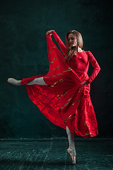 Image showing Ballerina posing in pointe shoes at black wooden pavilion