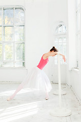 Image showing Ballerina posing in pointe shoes at white wooden pavilion