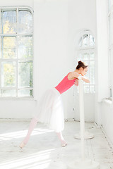 Image showing Ballerina posing in pointe shoes at white wooden pavilion