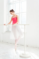 Image showing Ballerina posing in pointe shoes at white wooden pavilion