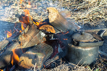 Image showing Burning fire and a kettle near the fire.