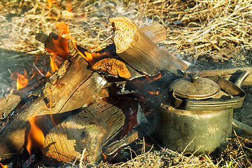 Image showing Burning fire and a kettle near the fire.