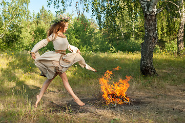 Image showing Attractive girl jump through fire