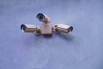 Image showing Three security cameras on blue wall