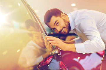 Image showing happy man touching car in auto show or salon