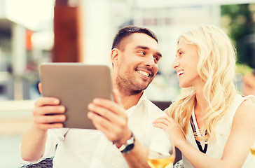 Image showing happy couple with tablet pc at restaurant lounge