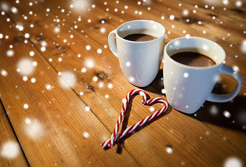 Image showing christmas candy canes and cups on wooden table