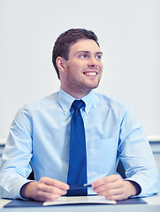 Image showing smiling businessman sitting in office