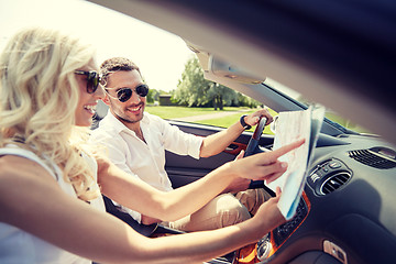 Image showing happy man and woman with map in cabriolet car