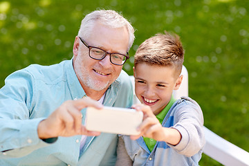 Image showing old man and boy taking selfie by smartphone