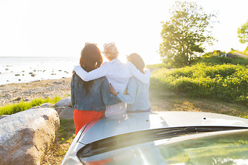 Image showing happy teenage girls or women near car at seaside