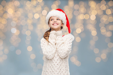 Image showing girl in santa hat dreaming over christmas lights