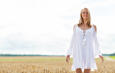 Image showing smiling young woman in white dress on cereal field