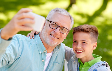 Image showing old man and boy taking selfie by smartphone