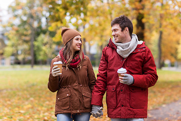 Image showing happy couple with coffee walking in autumn park