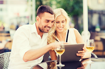 Image showing happy couple with tablet pc at restaurant lounge