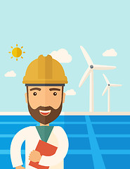 Image showing Man in solar panel and windmills.