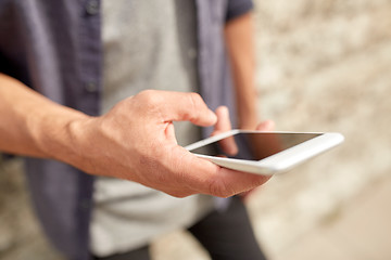 Image showing close up of man with smartphone at stone wall