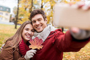 Image showing couple taking selfie by smartphone in autumn park