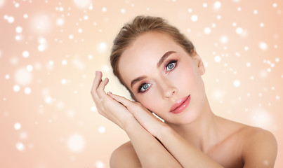 Image showing beautiful young woman face and hands over snow