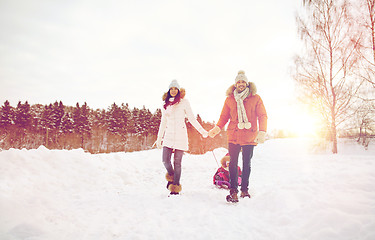 Image showing happy family with sled walking in winter outdoors