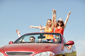 Image showing happy friends driving in cabriolet car at country