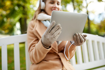 Image showing woman with tablet pc and headphones in autumn park