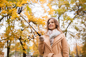 Image showing woman taking selfie by smartphone in autumn park