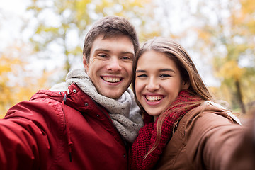 Image showing happy young couple taking selfie in autumn park