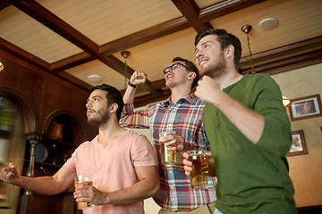 Image showing friends with beer watching sport at bar or pub